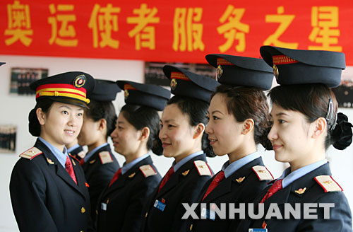 4月10日，动车组列车乘务员顶帽子练站姿。 当日，铁路济南客运段动车队对北京、上海、青岛方向动车组的80多名列车乘务员，进行站姿、行走、微笑等礼仪培训，用更好的服务迎接北京奥运。 新华社发(吕传泉 摄) 