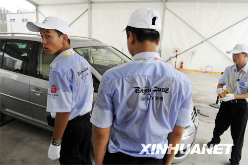 7月31日，奥林匹克中心区一安检口，安保人员正在认真核对车牌及证件。 在各涉奥场馆，严密的安保措施给赛事带来了安全，为奥运会提供安保服务的数万名安保人员在各自的岗位上一丝不苟，严格履行自己神圣的职责，用汗水和严谨保障奥运会的平安。