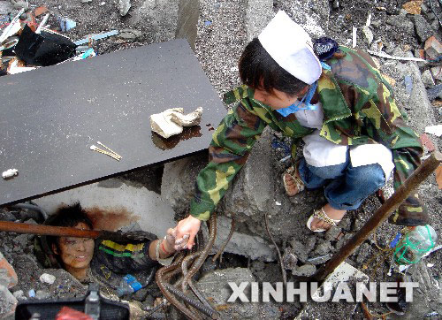 5月13日,护士顾云仙在北川的地震现场安慰一名被深埋的男孩,鼓励他